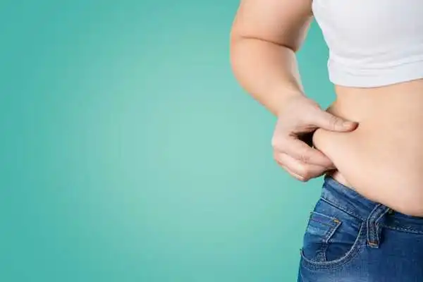 Image of woman pinching her love handles to show weight gain Chorley
